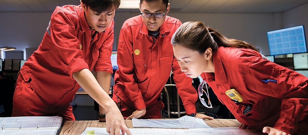 Three employees reviewing plans
