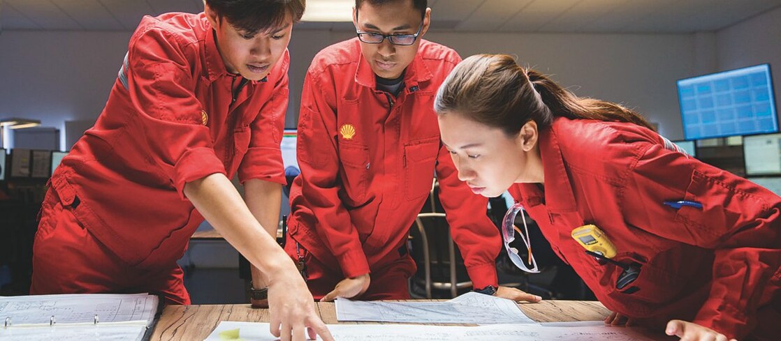 Three employees reviewing plans