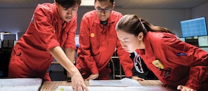 Three employees reviewing plans