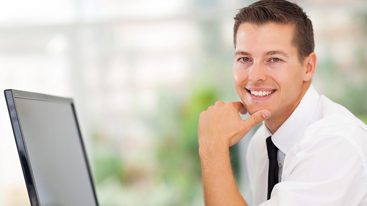 Man working on computer and smiling