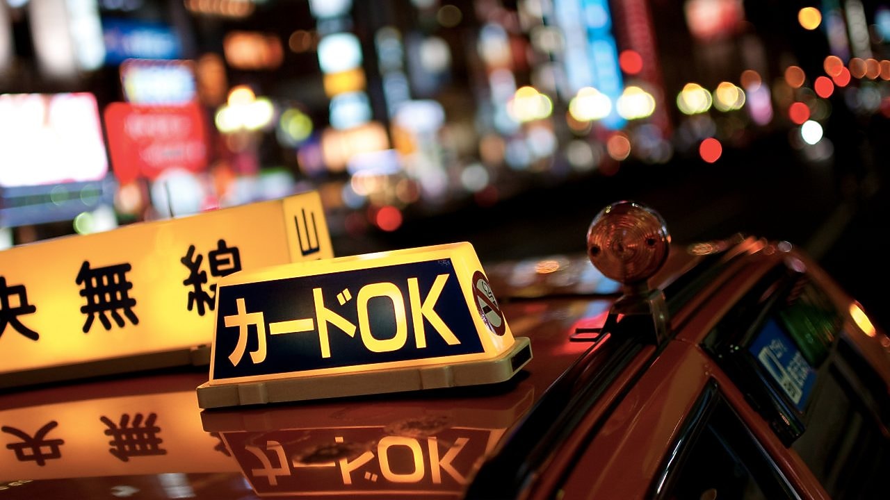 image of lit up taxi signs on the roof of a taxi in Japan.