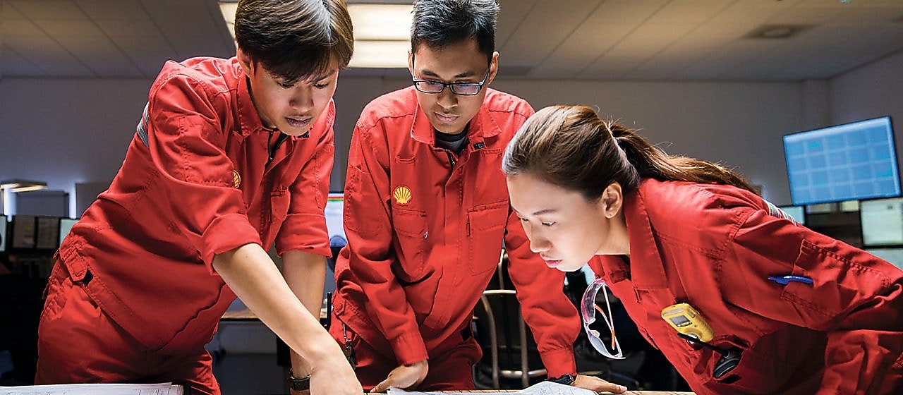 Three employees reviewing plans