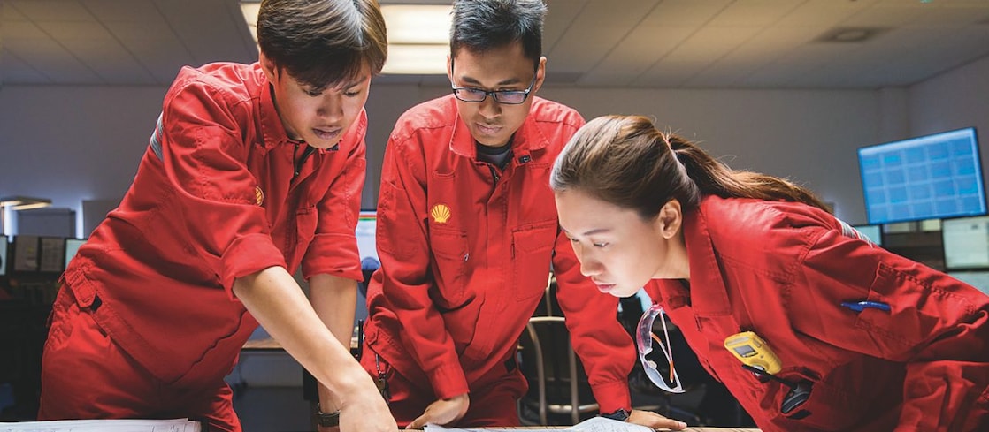 Three employees reviewing plans