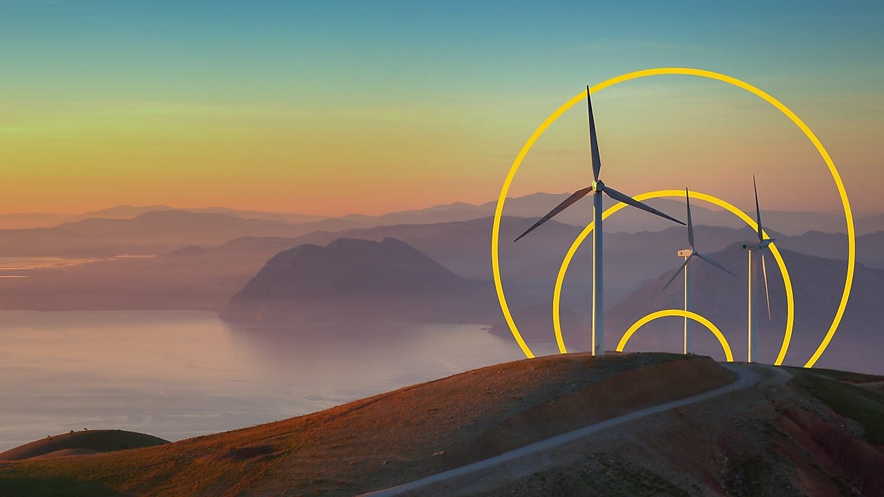 排出ネットゼロを説明したグラフの概略と丘の上に建てられた3基の風車の写真